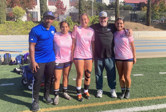 Coach Sheldon Thomas and Coach Billy Hansen alongside three of the many first-generation college students they’ve helped guide.