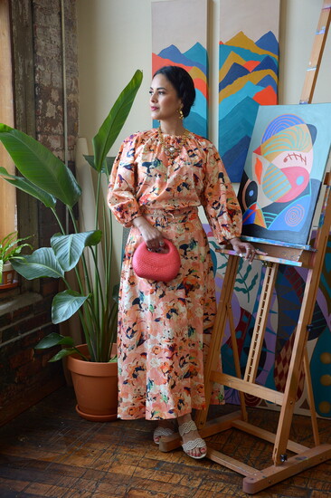 Rossina as Frida Kahlo wearing Ulla Johnson Sophea Cotton Skirt and Top, MONSHIRO Iris Long Earring, SERPUI Michelle Bun Wicker Handbag- Carriage House