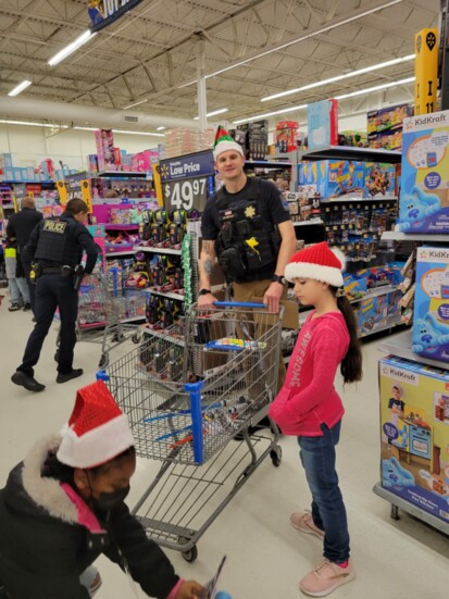 Officer Joshua Metcalf shops with kids to help choose Christmas gifts for their families.