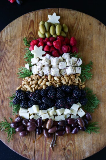 A charcuterie board in the shape of a tree or snowman with evergreen trimmings is quick and easy to assemble. 