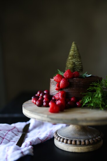 Dress up a double chocolate store bought cake with cascading berries held in place with toothpicks and a holiday cake topper. 