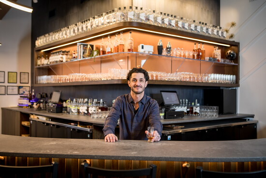 Distillery of Modern Art's Founder Seth Watson stands behind the bar at DOMA.