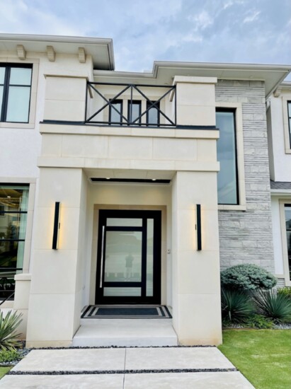 This modern pivot door gives this home by Shane Rickey Designs a wow factor.