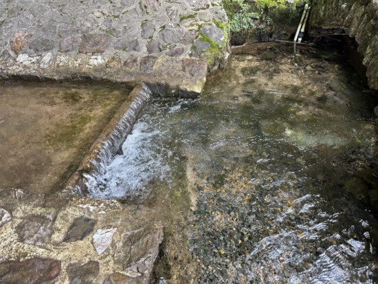 Spring water flowing into rock pond.