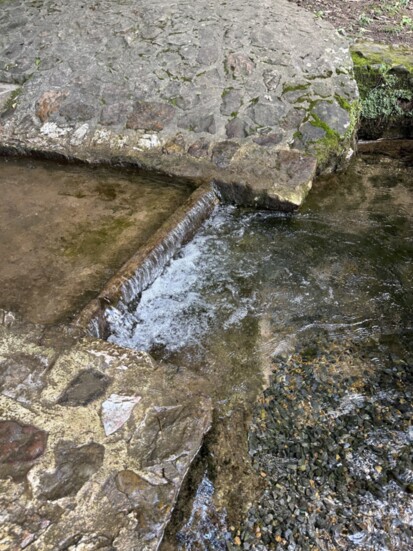 Spring water flowing into rock pond.