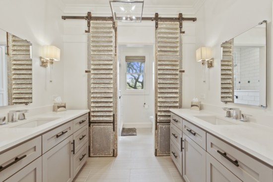 The more modern kids’ bathroom gets a touch of “Wow” as the Bay Hill team retrofitted a pair of antique shutters into the coolest door – giving nod to the home
