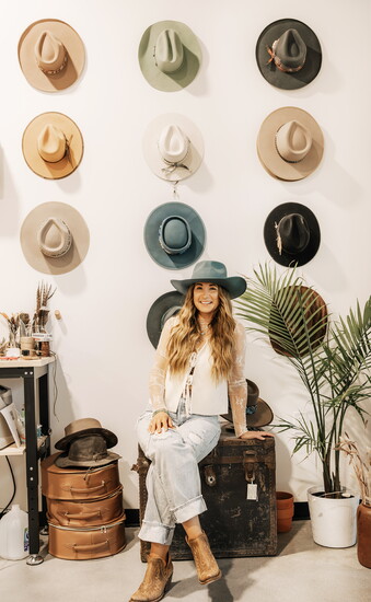 Skye of Soul + Muse sits surrounded by stories, each hat custom made with heart.  
