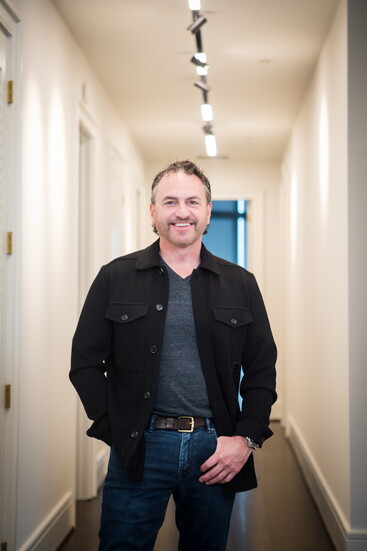 Keith stands in the hallway that shows the LED lighting in the ceiling of the hallway. 