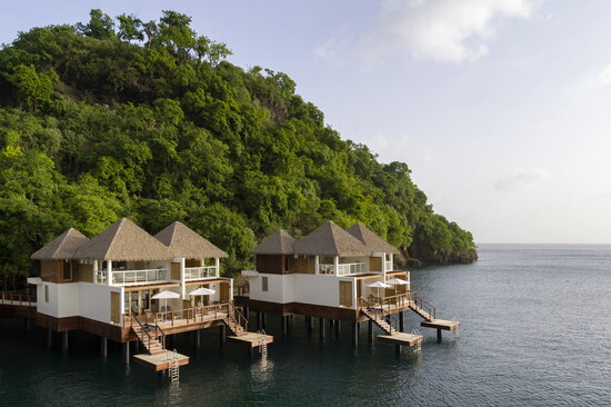 The Vincy Overwater Two-Story Villa is surrounded by lush forest and the soothing sounds of ocean waves lapping against the island.
