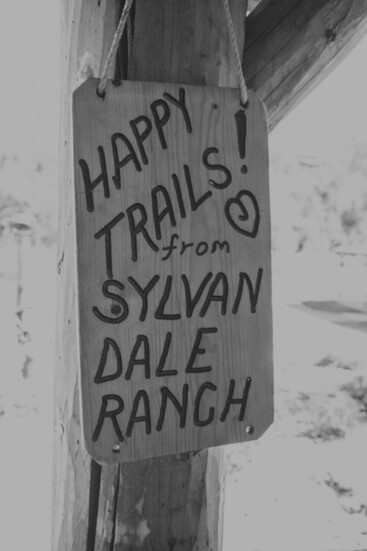 A sign hanging at Sylvan Dale Guest Ranch