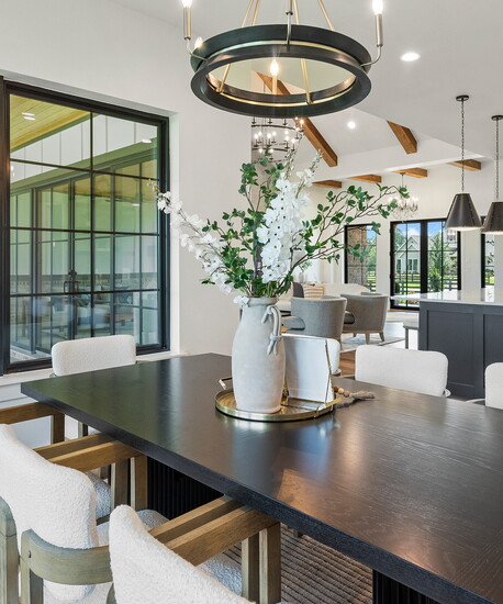 The dining room’s layered lighting, natural textures and open sightlines reflect the Collins plan’s balance of style and everyday livability.