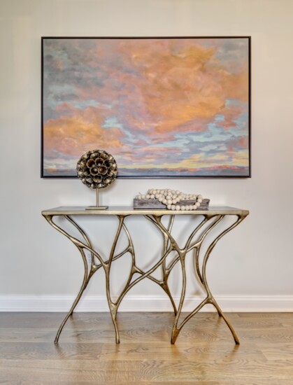 A soft and serene painting sets the mood for bedtime rituals and compliments the organic shape of this nature-inspired console table. Photography by Jim Fuhrman