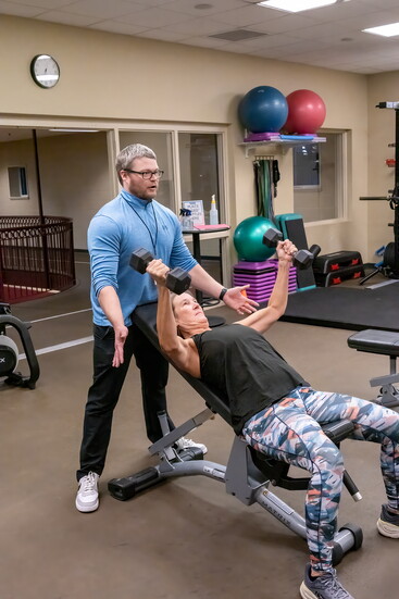 Trainer Andrew Murray helps client Julie Poole with her weight training.