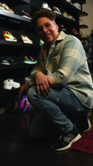 RanD Pitts, Owner of Evolve, Wears a Shirt by Wax London, Ksubi Denim Jeans and New Balance 327 Sneakers