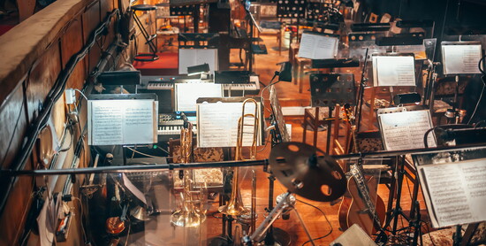 A sea of music stands awaits the first downbeat, each page holding a part of the whole.
