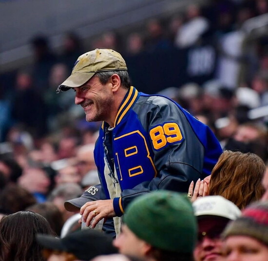 Jon Hamm JBS ‘89 cheers on the St. Louis Blues in Los Angeles while sporting his Class of ‘89 Blue & Gold Bomber letter jacket. 