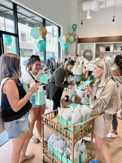 Members gather during a BODYBAR Woodforest community event featuring gifts and social time in the studio.