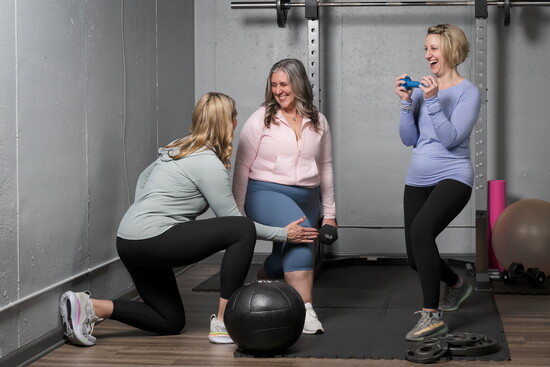 Rose Blake checks Christine G.'s form as she and Kristin L. practice lunges.