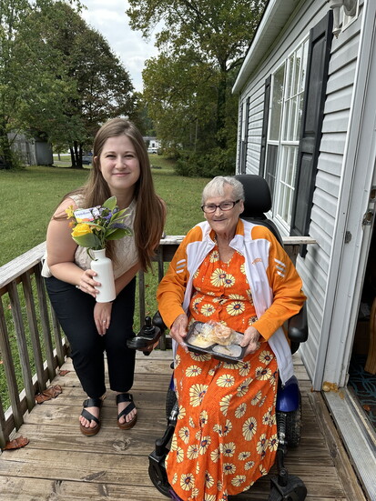 Sara Keel, MPH, program manager for Knoxville-Knox County CAC, delivers a meal and flowers from Random Acts of Flowers to Diane