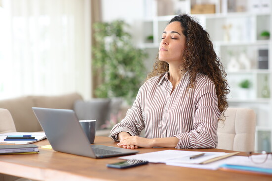 A person breathing deeply at their desk. 