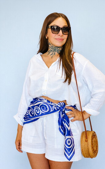 Angie has a blue silk scarf wrapped around her waist to add a chic touch to her outfit. 