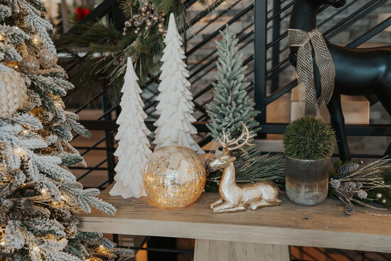 Monochrome trees, greenery, and a touch of gold bring quiet sophistication to this modern Christmas setting.