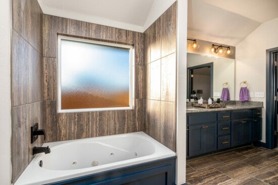 The master bath features a jetted tub, beautiful cabinetry and clean lines.