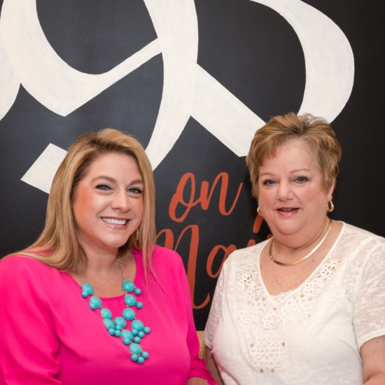 Cafe 393 co-owners Tanya McPherson and Nadine Simons pose in front of a custom interior sign.