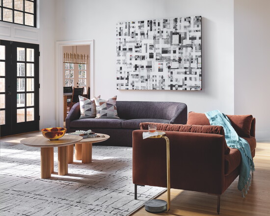 Original artwork is complemented by warmth of the Oliver Settee from Rowe and round coffee tables from Etsy