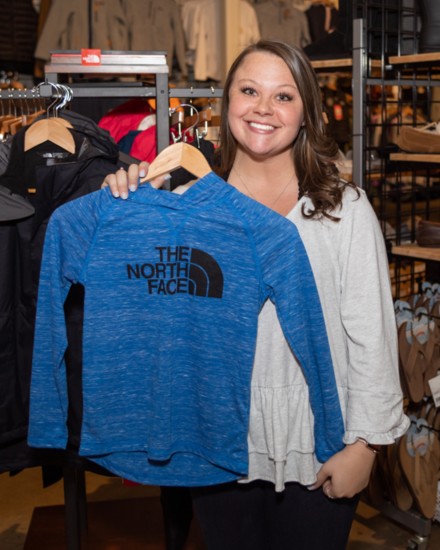 Makenzie Collier displays a shirt from the North Face, another eco-friendly brand.