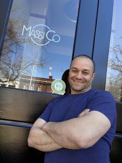Massimo Tullio with the "Sustainable Westport Champion" certification outside Massi Co.