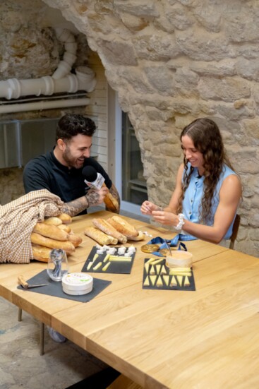 Kévin D'Andréa films an episode of "Breaking Baguettes" with Olympic gold medal swimmer Regan Smith at Le Musée du Fromage in Paris.