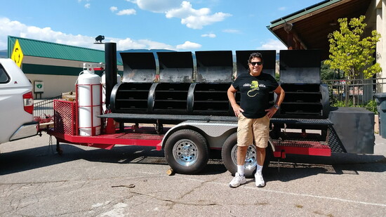 Chef Jimmy Nadell alongside his custom-made 18 ft. BBQ smoker.