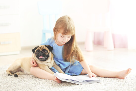 Child reading to a dog.