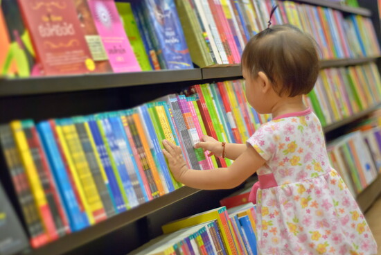 Child choosing a book in a library.