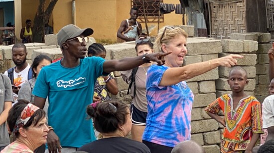 NBI President and trauma therapist Dr. Lori Basey shares a message from the Bible with a village filled with polio victims in Sierra Leone, West Africa.