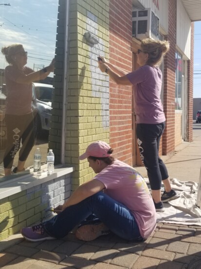 Back home in OKC, volunteers paint the exterior of "Base 907." (Photo by Andrew Griffin)