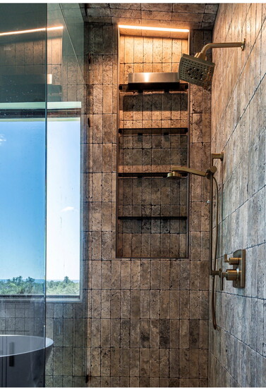 Master shower with vertical tavertine tile and smoked glass enclosure
