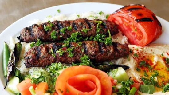 Fresh off the grill: beef kofta kebabs with rice, salad, hummus, and pita.