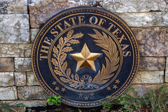The Texas state seal centers the Lone Star within live oak and olive branches, symbols of strength and peace.