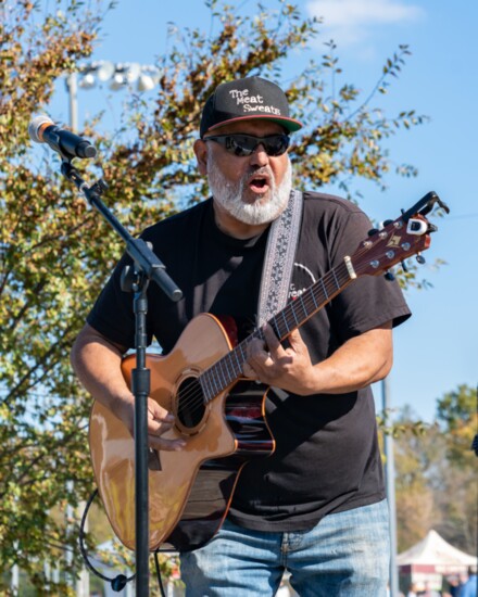 Meat Sweats owner Martin Tudon performs with his band at a community event.