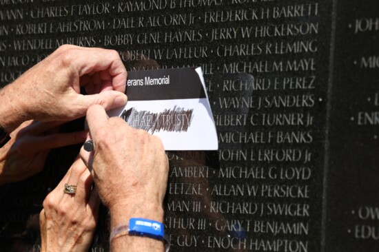 Honor Flight veterans etching names at the Vietnam War Memorial
