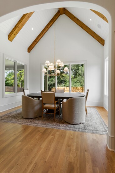 Elegant dining space boasts vaulted ceilings and striking wooden beams.