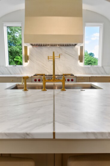 Luxurious Calcutta marble counters accented with exquisite solid brass inlay.