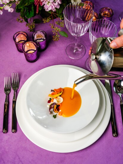 Edible flowers and a hand-poured soup elevate this first-course's wow factor.