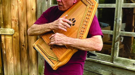 Ricky Levitan demonstrate his Autoharp outside his Media workshop 