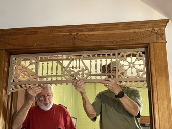 Bill Hull and Dave Dyerwith the Central Oklahoma Woodturner's Association install some of the original wooden scrollwork.