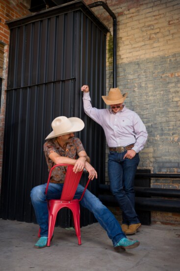 Tater and Logan are both wearing Cinch jeans and shirts. Tater has on teal boots from Tyler Lyles and Logan is wearing a hat handmade from Catalina Hat Company