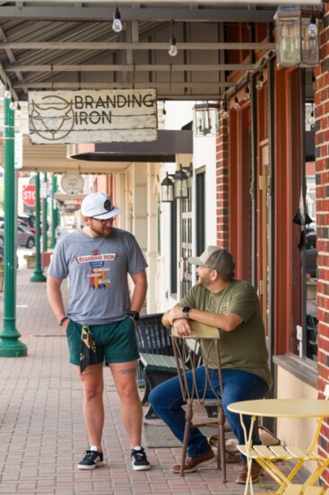 Adam Isabel and Keath Krueger stopping to chat at the Men's Store, Branding Iron Custom Goods on Main St. 