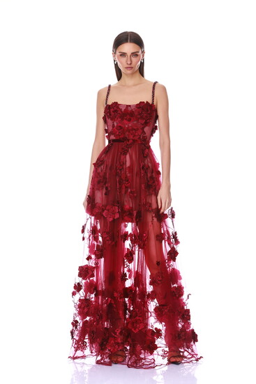 A deep burgundy sheer gown covered in dimensional floral appliqués with delicate embellished straps